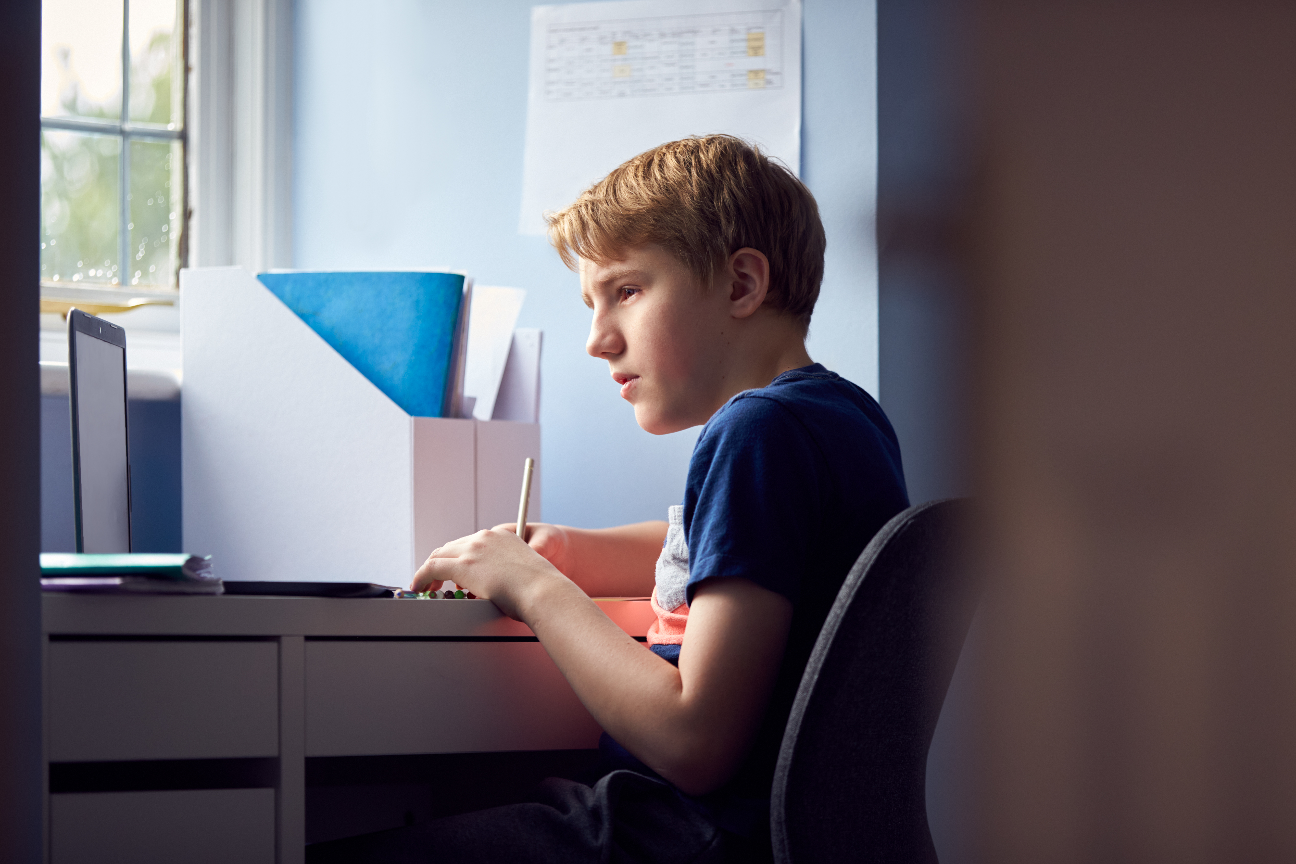 Boy,Sitting,At,Desk,Home-schooling,Using,Laptop,For,Online,Learning